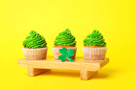 Tasty cupcakes for St. Patrick's Day on color backgroundの写真素材