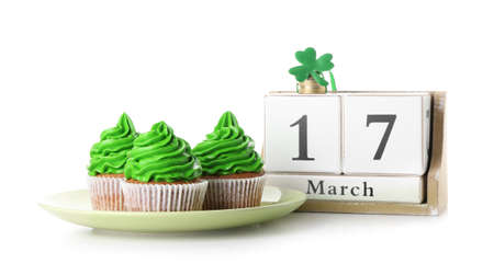 Tasty cupcakes for St. Patrick's Day and calendar on white backgroundの写真素材
