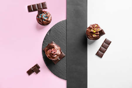 Composition with tasty chocolate cupcakes on color background