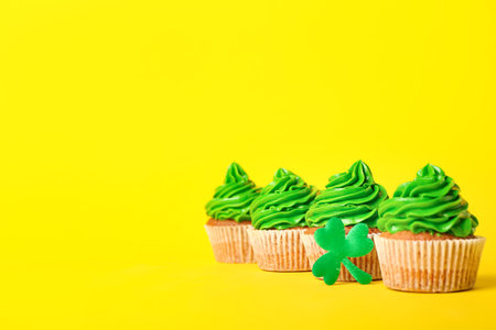 Tasty cupcakes for St. Patrick's Day on color backgroundの写真素材