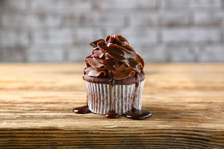 Tasty chocolate cupcake on wooden tableの写真素材