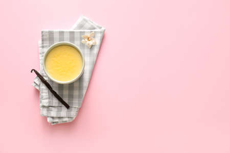 Ramekin with tasty vanilla pudding on color background