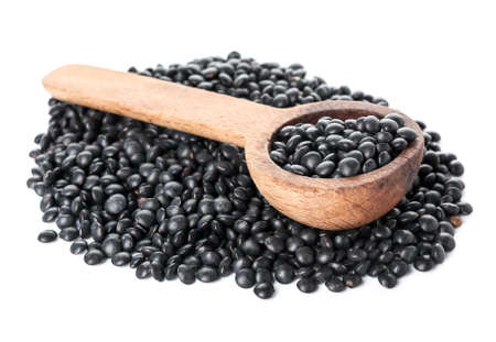 Spoon with black lentils on white backgroundの写真素材