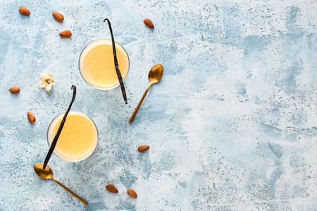 Glass bowls with tasty vanilla pudding on color backgroundの写真素材