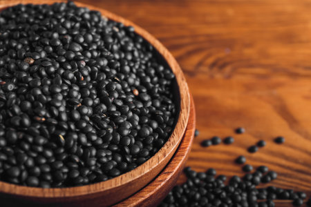 Bowl with black lentils on wooden backgroundの写真素材