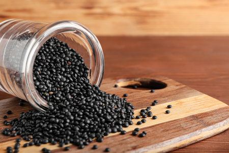 Glass jar with black lentils on wooden backgroundの写真素材