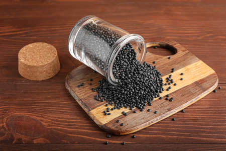 Glass jar with black lentils on wooden backgroundの写真素材