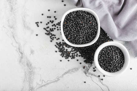 Bowls with black lentils on light backgroundの写真素材