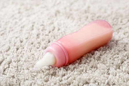 Bottle of milk for baby on carpet, closeupの写真素材