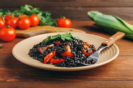 Plate with tasty cooked lentils and vegetables on tableの写真素材