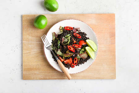 Plate with tasty cooked lentils and vegetables on tableの写真素材