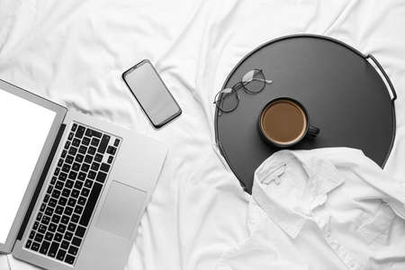 Composition with cup of coffee and mobile phone on bedの写真素材
