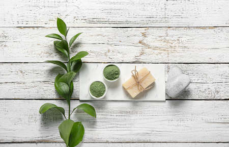 Composition with henna powder and soap on light wooden background