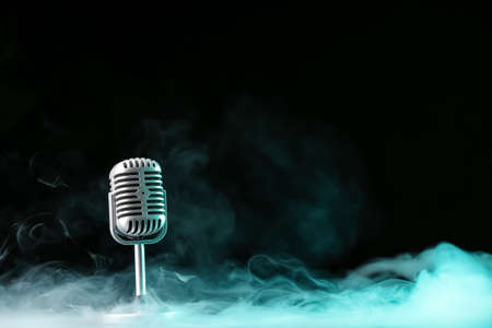 Retro microphone on dark background with fumeの写真素材