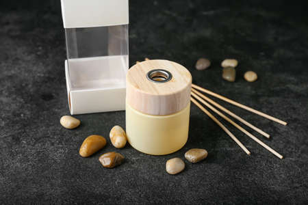 Reed diffuser with sea stones on dark background