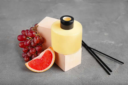 Reed diffuser with fruits on grunge background