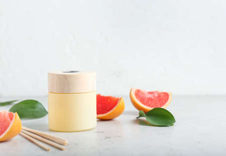 Reed diffuser with grapefruit on white background