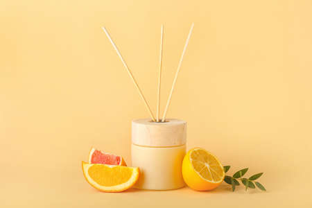 Reed diffuser with citrus fruits on color backgroundの写真素材
