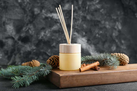 Coniferous reed diffuser with cinnamon on grunge background