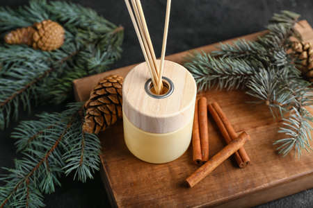 Coniferous reed diffuser with cinnamon on grunge background