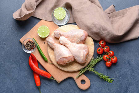 Board with raw chicken legs on dark backgroundの写真素材