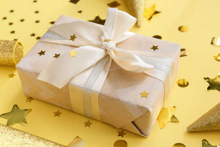 Gift box and confetti on color background
