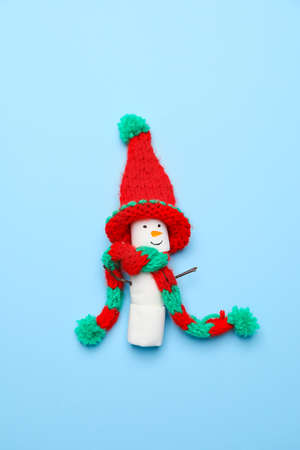 Funny snowman made of marshmallows on color backgroundの写真素材
