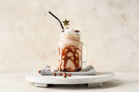 Mason jar of sweet chocolate milkshake on table