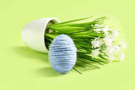 Creative composition with Easter egg and flowers on color background