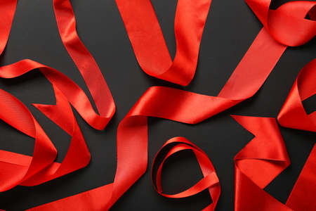 Shiny red ribbons on dark background, closeupの写真素材