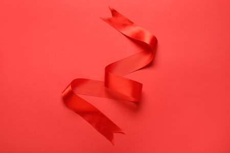 Shiny red ribbon on color backgroundの写真素材
