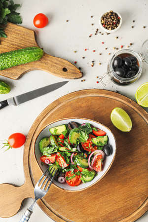 Bowl of fresh salad with vegetables on tableの写真素材