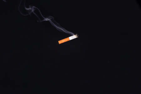 Smoking cigarette on dark backgroundの写真素材