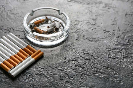 Ash tray and cigarettes on dark backgroundの写真素材