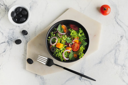 Bowl of fresh salad with vegetables on light backgroundの写真素材