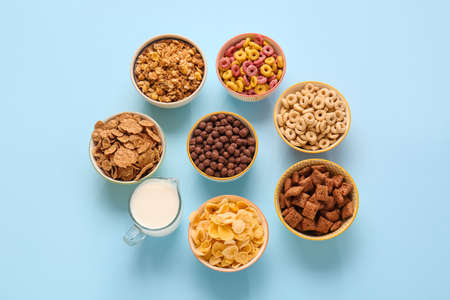 Bowls with different cereals and milk on color backgroundの写真素材
