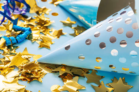 Party cones and confetti on color background