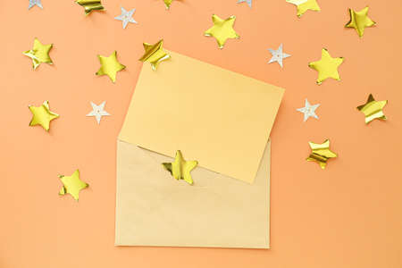 Blank paper sheet with envelope and confetti on color backgroundの写真素材