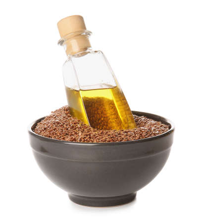Bottle of flax oil and seeds on white backgroundの写真素材