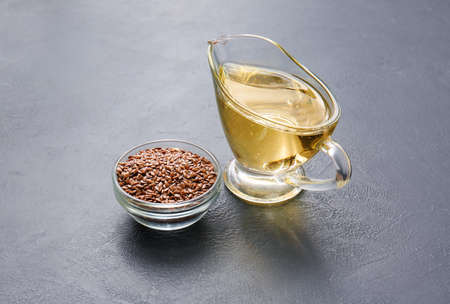 Gravy boat with flax oil and seeds on dark backgroundの写真素材