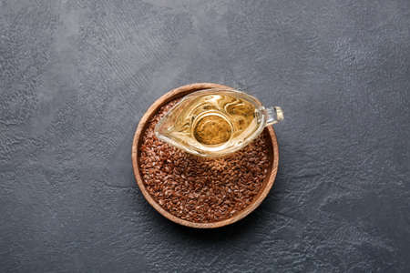 Gravy boat with flax oil and seeds on dark backgroundの写真素材