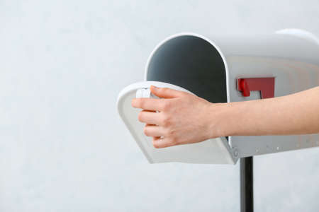 Woman with mail box on light backgroundの写真素材