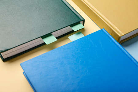 Books with bookmarks on color background, closeup