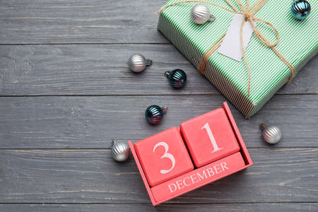 Calendar with date of December 31, decorations and gift boxes on gray wooden backgroundの写真素材