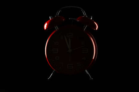 Silhouette of alarm clock on dark background