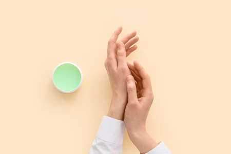 Woman with hand cream on light backgroundの写真素材
