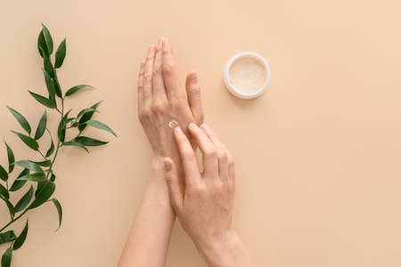 Woman applying natural hand cream on light backgroundの写真素材