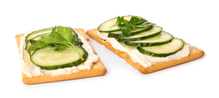 Tasty crackers with cheese and cucumber on white backgroundの写真素材