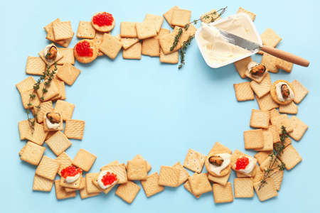 Frame made of tasty crackers on color backgroundの写真素材
