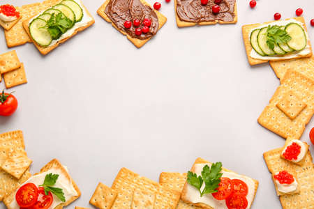 Frame made of tasty crackers on gray background